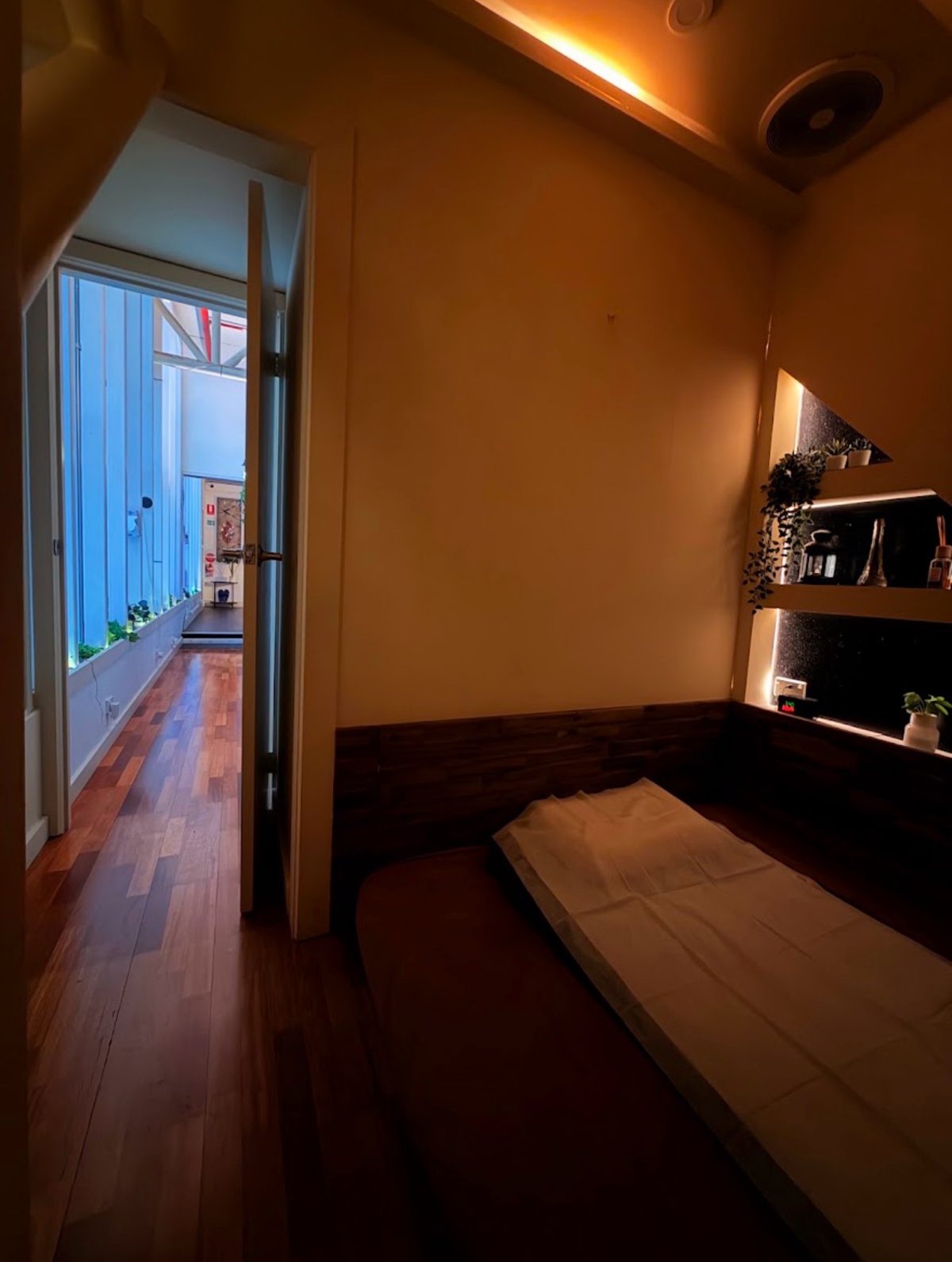 Warmly lit treatment room opening onto the studio hallway