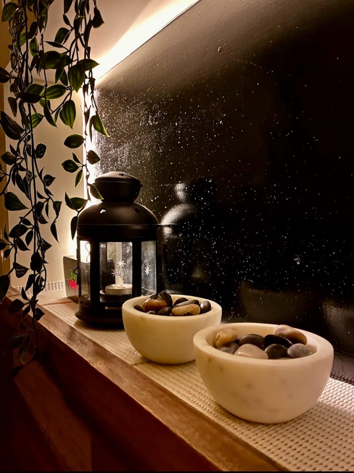 Lantern and stone bowls beside trailing plants