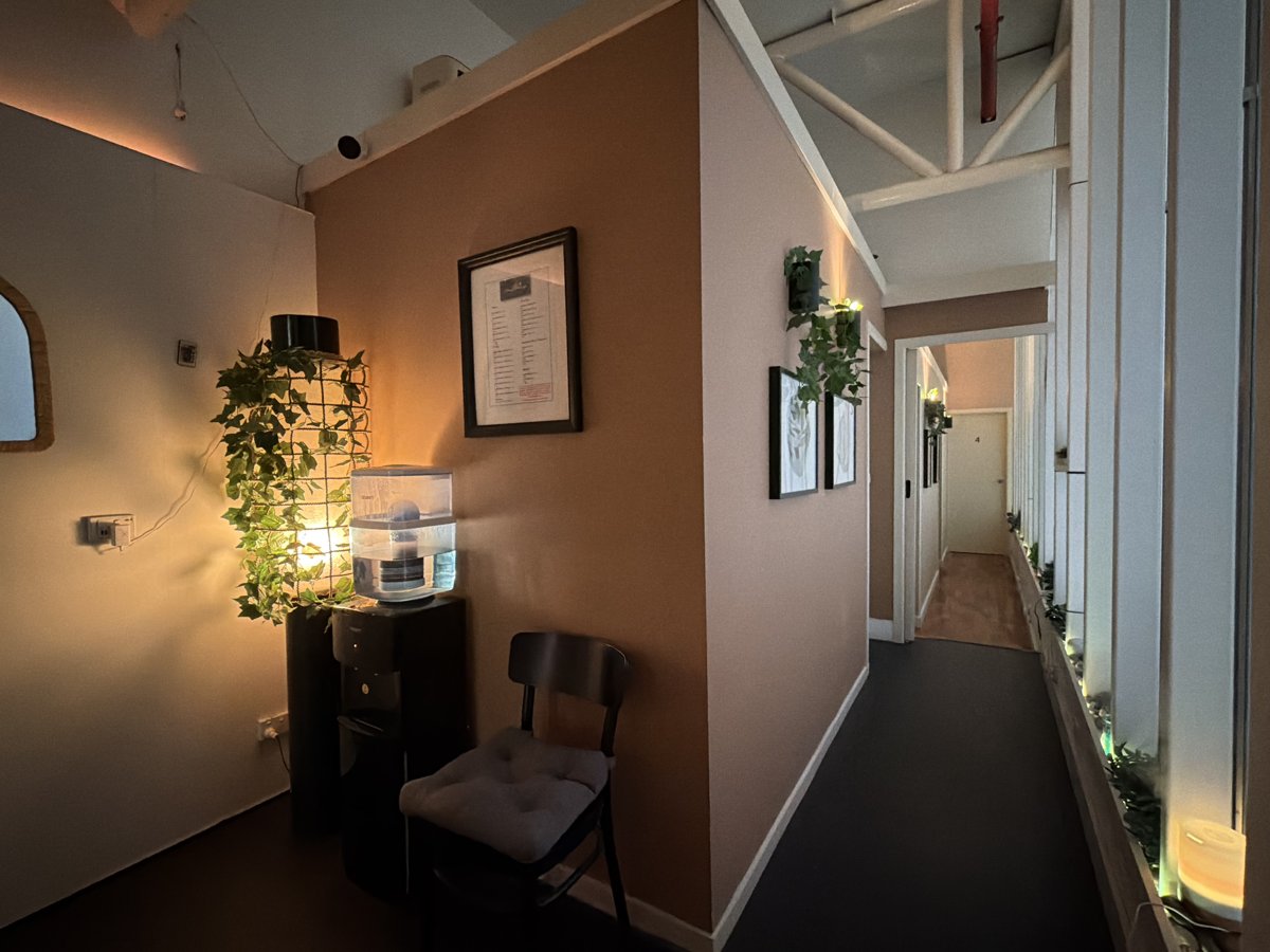 Studio seating area with a softly lit plant lamp and hallway